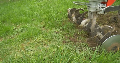 Closeup of hand motor plow blade throwing ground and grass. Cloudy 動画素材 75179621