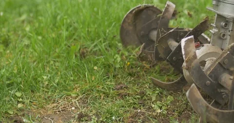Closeup of hand motor plow blade throwing ground and grass. Cloudy 库存影片 75180519