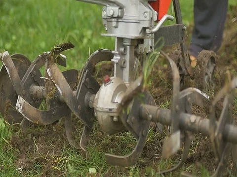 Closeup of hand motor plow blade throwing ground and grass. Slow motion Stock Footage 75181427