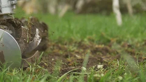 Closeup of hand motor plow blade throwing ground and grass. Slow motion Stock Footage 75183639