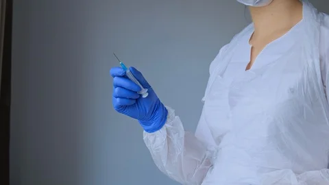 Closeup of the hand of a nurse who opens a syringe. The doctor prepares the tool Stock Footage 129496131