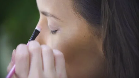 Closeup hand paint the model's eyes, makeup applied to the face model Stock Footage 73106583