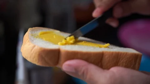 Closeup hand paste butter on bread, slow-motion Stock Footage 130048555