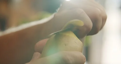 Closeup of hand peeling potato with sharp knife. 4K Slow Motion Stock Footage 117291452