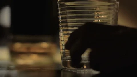Closeup hand pouring alcohol from bottle in glass, drinking and putting on table Stock Footage 85216268