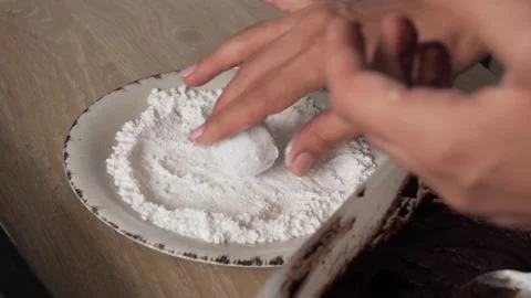Closeup of hand preparing cracked marble biscuits on a rustic tabletop Vidéo 293099079