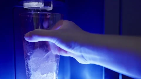 Closeup hand pressing the button on an automatic ice dispenser in a refrigerator Stock Footage 297249198