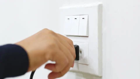 Closeup hand pull plug out from socket. Energy saving concept Stock Footage 196910679