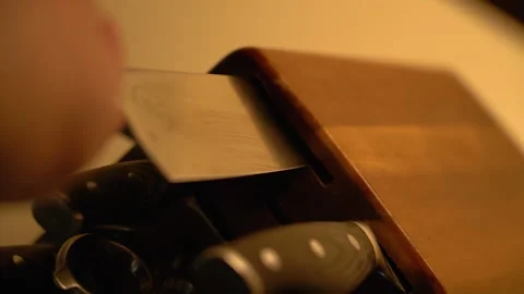 Closeup of hand pulling large butcher knife from knife block and examining blade 스톡 동영상 243502507
