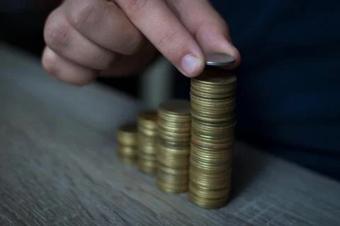 Closeup of hand put Coins to stack of coins,Concept Saving money. Stock Photos