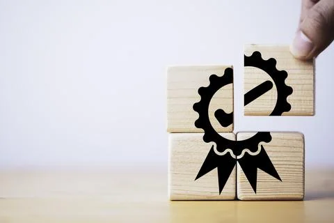Closeup of hand putting to assemble quality assurance icon which print scre.. Stock Photos