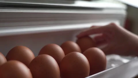 Closeup hand putting an eggs in the fridge shelf Stock Footage 131715972
