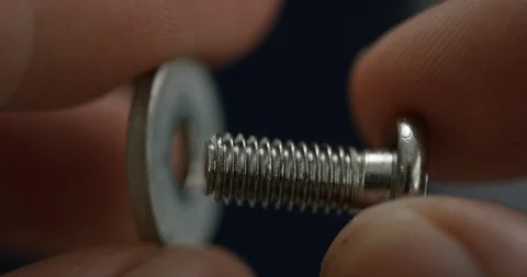 Closeup of hand putting small screw through washer Stock Footage 105543676