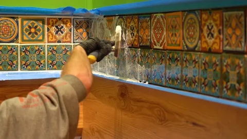 Closeup of hand with rubber glove using spatula float to apply grout to Stock Footage 101434783
