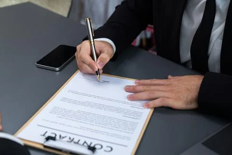 Closeup hand signing contract document with pen. Fervent. Stock Photos