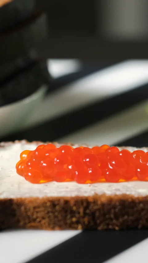Closeup of hand spreading red caviar on bread Stock Footage 322220395