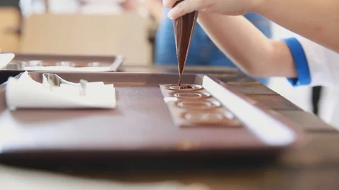 Closeup hand squeeze chocolate to the tray Stock Footage 109613942