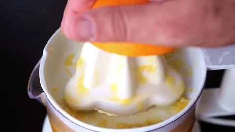 Closeup of hand squeezing an orange with juicer Stock Footage