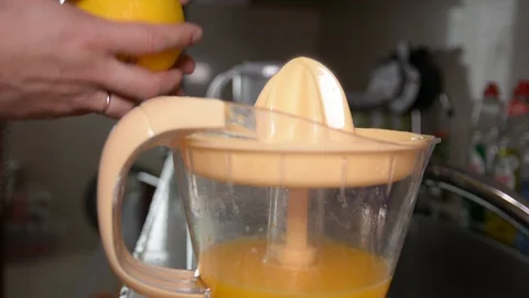 Closeup of a hand squeezing an orange with a juicer 스톡 동영상 89479913