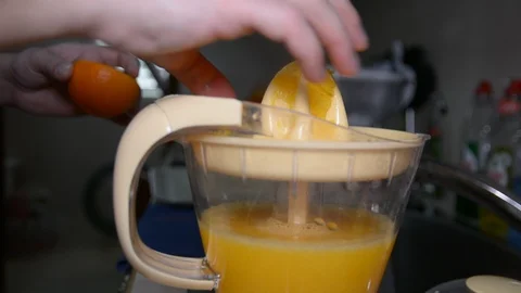 Closeup of a hand squeezing an orange with a juicer 스톡 동영상 89480026