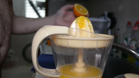 Closeup of a hand squeezing an orange with a juicer 動画素材 89480361