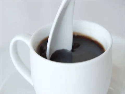 Closeup hand stir sugar in a white coffee cup Stock Footage 76509000