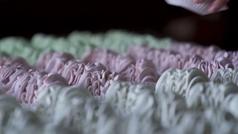 Closeup hand takes two pink marshmallow cookies from big group served on table. Stock Footage 215924063