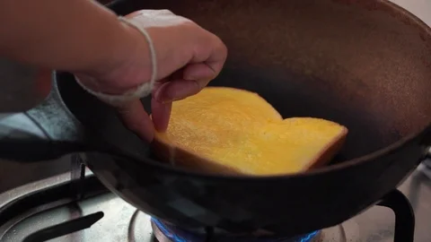 Closeup hand toasting butter bread in pan, slow-motion  Stock Footage 116387252