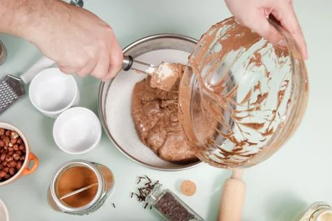 Closeup hand transferring cake mixture cake pan Stock Photos
