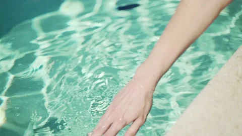 Closeup of a hand trying water in a pool. Turquoise fresh water in the pool on a Stock Footage 134516336