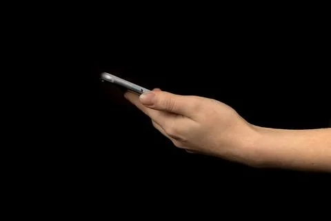 Closeup of hand using mobile phone against black background photo Stock Photos