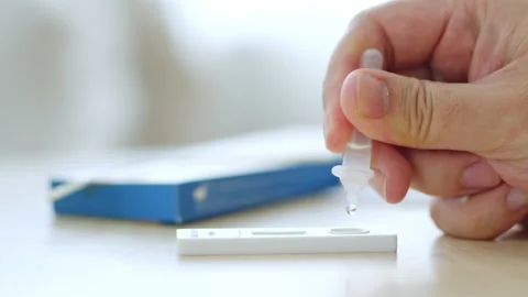 CLoseup hand using rapid antigen test kit (ATK) for self test at home Stock Footage 196907745