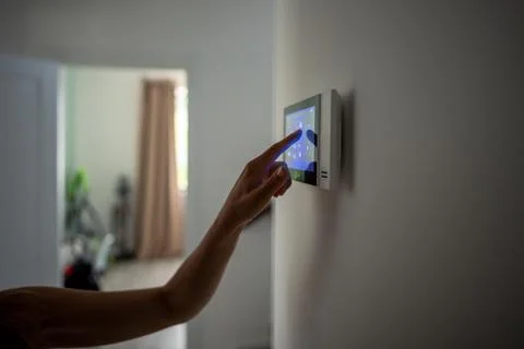 Closeup hand using smart home panel, touching screen with connected applian.. Foto stock