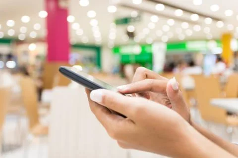 Closeup hand using smart phone in department store urban lifestyle Foto stock
