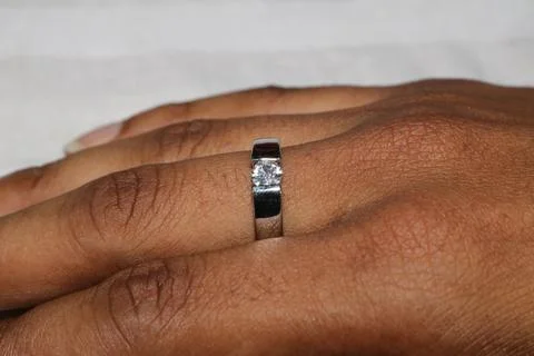 Closeup of a hand wearing a silver ring with a diamond on the finger  hand .. Foto stock