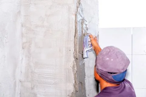 Closeup hand of worker plastering cement at wall. Stock Photos
