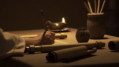 Closeup of hand writing letter on paper scroll, ancient scroll and clay oil lamp Stock Footage