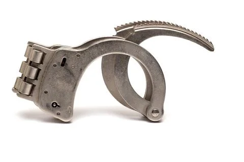 Closeup handcuffs open locking bars white background Close up of solid iro... Foto stock