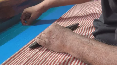 A closeup of a handloom worker's hand tying a knot to a thread using a specific Stock Footage 312783994