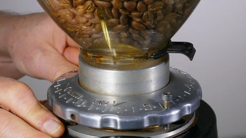 Closeup of a hands adjusting a commerical grinder to grind fresh coffee beans. Video stock 121663058