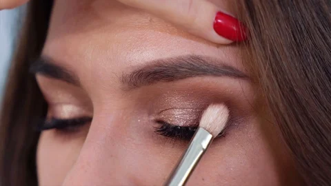 Closeup of hands applying eyeshadows to young woman eyelids in slow motion Stock Footage 101653905