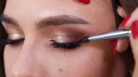 Closeup of hands applying eyeshadows to young woman eyelids in slow motion Stock Footage 101654075