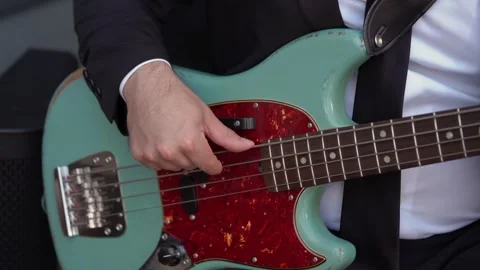 Closeup Of Hands On Bass Guitar Strings, Musician In Formal Attire Playing Deep Stock Footage 323771087
