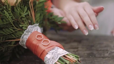 Closeup Hands of bride and groom and rings on wedding bouquet. Marriage concept Stock Footage 80995544