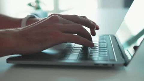 Closeup of hands of business person typing on laptop keyboard at the desk in Stock Footage 241745517