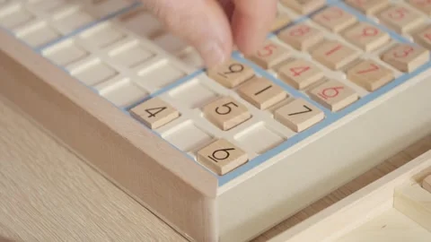 Closeup hands carefully placing number into Sudoku puzzle, senior man focus.. Stock Footage 309883441