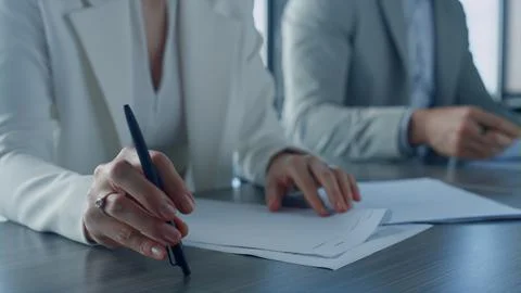 Closeup hands checking papers on corporate meeting. Business partners exchanging Stock Photos