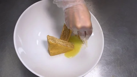 Closeup on the hands of a chef preparing a dessert in a restaurant Stock Footage 77524597