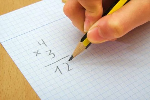 Closeup on the hands of a child doing maths. Multiply. School concept Stock Photos
