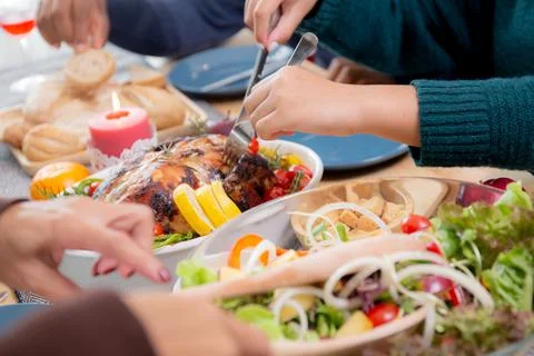 Closeup hands of children using knife slicing meat of turkey roasted on dishe Stockfoto's
